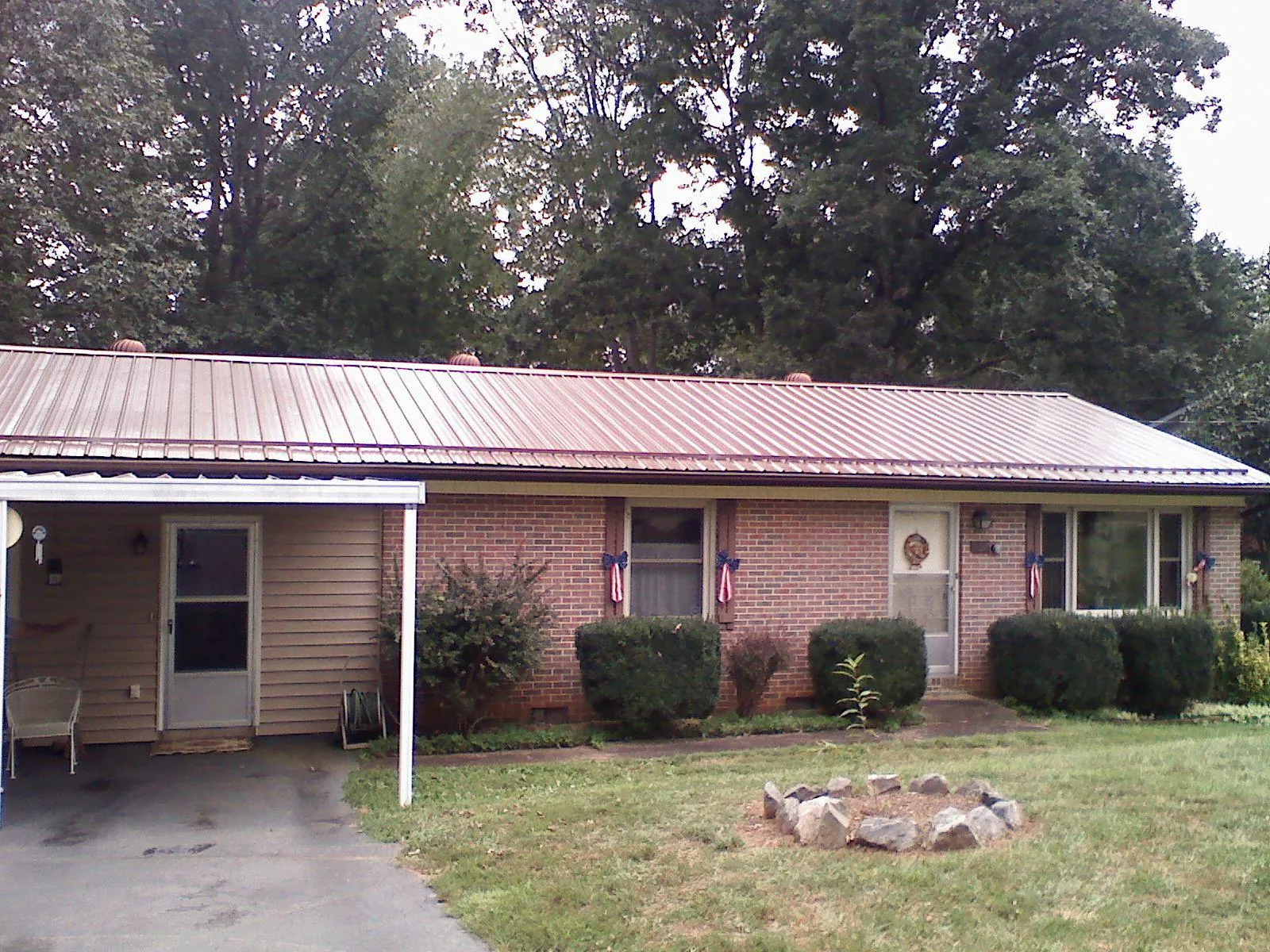 Bronze metal roof and carport on a brick ranch home — Roof Repair work by our crew in Mary D